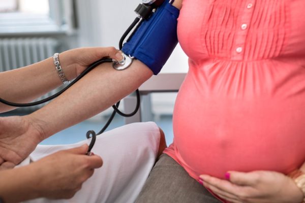 Nurse measuring pressure of pregnant woman in ambulances